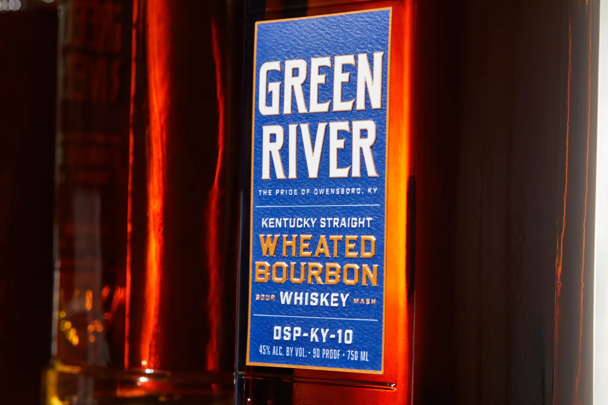 Green River Kentucky Straight Wheated Bourbon bottle with blue label under red neon light