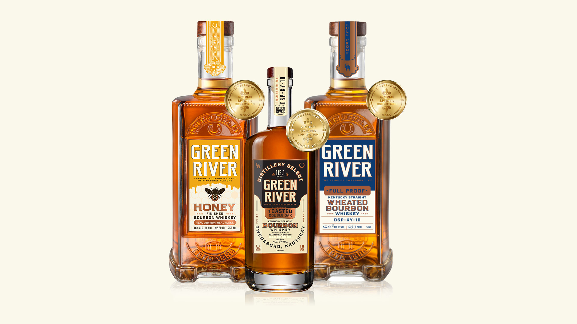 Three Green River bourbon whiskey bottles with gold award medals on cream background
